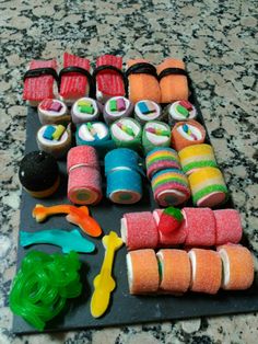 there are many different sushi rolls on the counter top, and one is made out of fondant