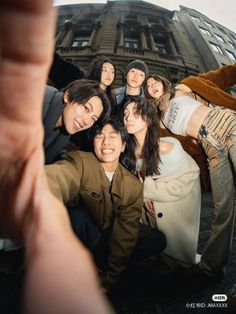 a group of people taking a selfie in front of a building