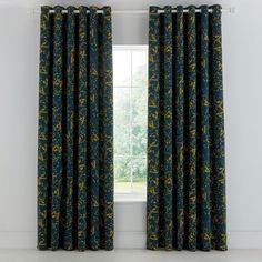 the curtains in this room are decorated with blue and yellow floral print, while the window is