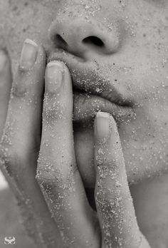 black and white photograph of a woman's face covered in sand