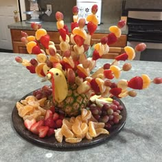 a platter filled with fruits and vegetables on top of a kitchen counter