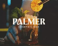 a hand holding a cocktail glass with orange slices on it and the words palmer cocktail bar