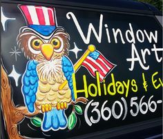 an advertisement on the side of a car for windows art, with an owl holding a flag