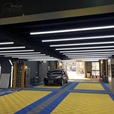 a car is parked in the garage with yellow and blue stripes on the floor next to it