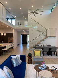 a living room filled with lots of furniture and a staircase leading up to the top floor