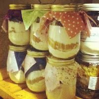 jars filled with different types of food on top of a wooden shelf next to a ruler