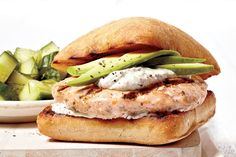 a chicken sandwich with cucumbers and ranch dressing