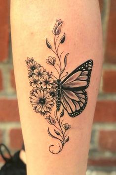 a butterfly and flowers tattoo on the leg