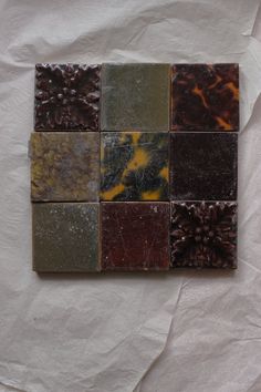 several different types of marbles are arranged on a piece of white paper with brown and yellow accents