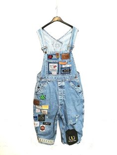 These short denim overalls are so stylish and original that we only see them! With its multiple vintage badges all sewn by hand and its oversized cut, it guarantees you an authentic and inimitable look.Characteristics Patchie D denim overalls Size L women Size S men Adjustable straps Wide boyfriend fit Two chest pockets, two back pockets and two front pockets. Flower patch and other hand-sewn leather and fabric patches. Tears and pants on the legs. Unique creation by Cleo n Mama ONLY UNIQUE PEOP Jean Overall Outfits, Farmer Overalls, Short Denim Overalls, Style Salopette, Vintage Badges, Silly Clothes, Overalls Fashion, Blue Overalls, Denim Backpack