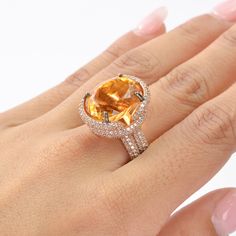 This exquisite ring features a stunning Citrine as the center stone, radiating vibrant hues of golden yellow. The Citrine is complemented by an array of White Zircon accent stones, adding a touch of brilliance and sparkle to the piece. The design showcases a luxurious rose gold-plated band, enhancing the warm tones of the Citrine. The intricate setting highlights the gemstone's natural beauty, making it a perfect statement piece for any occasion. This piece is inspired by the Art Deco era, known Formal Citrine Open Ring Jewelry, Formal Open Ring Citrine Jewelry, Dazzling Yellow Rings With Halo Setting, Elegant Round Diamond Ring, Elegant Round Diamond Ring With Stones, Elegant Citrine Crystal Ring, Elegant Citrine Open Ring, Elegant Open Ring Citrine Rings, Elegant Open Citrine Ring