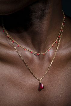 Anet's Collection seed of life single pomegranate seed Necklace in Gold paired with red dotted necklace. In Armenian mythology the pomegranate symbolizes fertility and abundance. The fruit is the Armenian symbol of life and tradition tells us that each mature pomegranate has 365 seeds, one for each day of the year. Length: 16" & 18" Pom seeds: Formica 2mm 14 K gold plated double necklace, can be used separately or together Brass casting Pomegranate Seed Necklace, Red Coral Spiritual Necklaces, Spiritual Red Coral Necklaces, Spiritual Red Coral Necklace, Red Coral Pendant Necklace, Spiritual Red Coral Jewelry As A Gift, Traditional Double Strand Necklace As A Gift, Spiritual Red Coral Jewelry, Red Polished Beads Necklace For Meditation