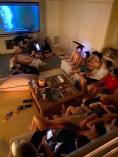 a group of people sitting in a living room watching tv