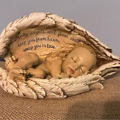 a ceramic statue of a sleeping baby in a basket with the words, gently angels sent from heaven to keep you from brain damage