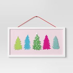 a pink and green christmas tree print hanging on a wall