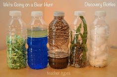 there are many plastic bottles that have plants in them and some water on the table