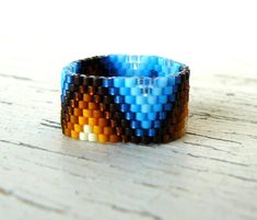 a blue and brown bracelet sitting on top of a wooden table