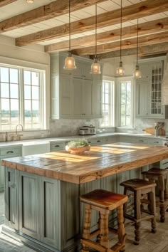 a large kitchen island with stools in the center and two lights hanging from the ceiling