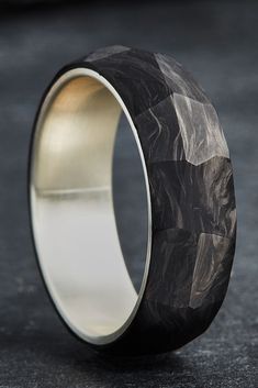 a black and white wedding ring with gold inlays on it's side