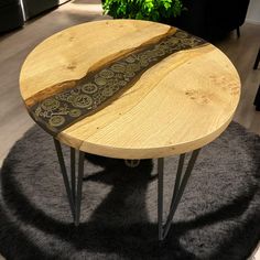 a wooden table sitting on top of a black rug next to a potted plant