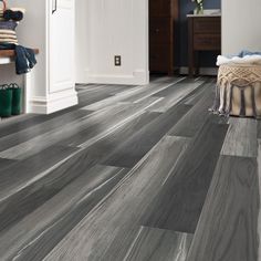 a room with grey wood flooring and white walls