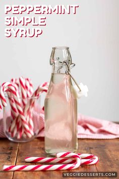 peppermint simple syrup in a glass bottle with candy canes on the side