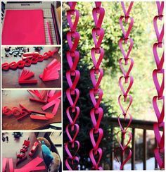 some pink paper hearts are hanging from the side of a window and on top of a table