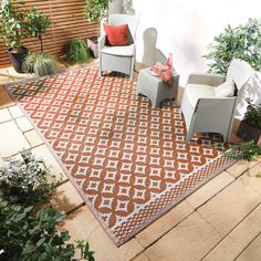 a brown and white area rug sitting on top of a wooden floor next to chairs