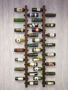 several wine bottles are lined up on a wooden rack in front of a white wall