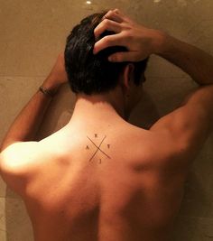 a man with a cross tattoo on his back