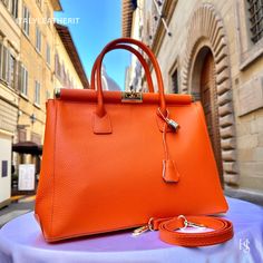 This bag has been made of the best genuine leather by local master crafters of Florence in Italy, designed for women who only accept premium Italian quality and luxury leather bags and modern Italian fashion. . Size: Height: 28 cm/11.02 inches. Width: 33 cm/12.99 inches. Depth: 15 cm/ 5.91 inches. Color: orange . The story of this bag:  In the heart of Italy, where artistry and craftsmanship have flourished for centuries, a group of skilled artisans pours their passion into creating exquisite le High-end Office Bags With Smooth Grain, High-end Smooth Grain Office Bags, High-end Everyday Bag With Smooth Grain, High-end Bags With Leather Lining For Daily Use, High-end Rectangular Bags With Smooth Grain, High-end Bag For Everyday Use, High-end Smooth Grain Bag For Everyday Use, Classic Orange Bags With Leather Handles, Luxury Orange Satchel For Daily Use