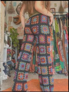 a woman standing in front of a pile of clothes with her back turned to the camera