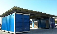 two blue and white shipping containers sitting next to each other in a parking lot under a metal roof