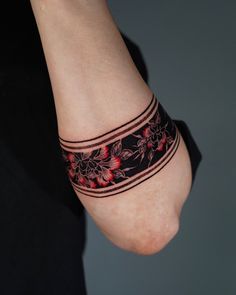 a woman's arm with a tattoo on it that has red flowers and stripes