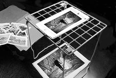 an ipad is sitting on top of a table with pictures and papers in front of it