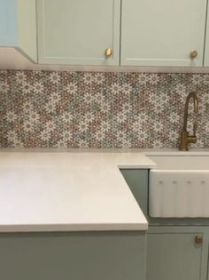 a kitchen counter with a sink and cupboards in the backround, next to an oven