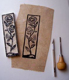 two pieces of paper with designs on them next to a pen and inking tool