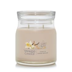 yankee candle with vanilla and white orchids in a glass jar on a white background