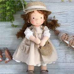 a doll with red hair wearing a dress and hat, holding a purse in her hands