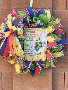 a colorful wreath hanging on the side of a brick wall with an image of a child's book