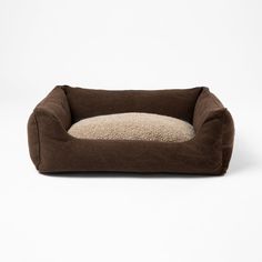 a brown dog bed with a white background