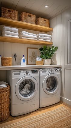 a washer and dryer sitting in a room next to some shelves filled with towels