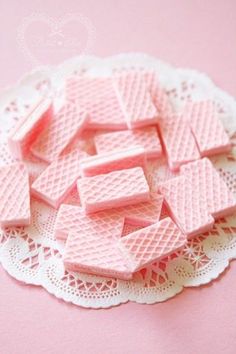 small pink squares are sitting on a doily