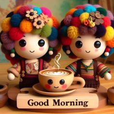 two dolls are sitting next to each other with coffee in front of them and the words good morning written on it