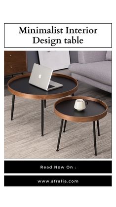 two round tables with black tops and wooden legs, one has a laptop on it