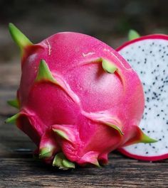 a dragon fruit cut in half on a wooden table