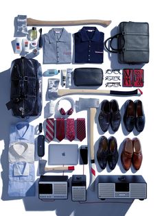 an assortment of men's clothing and accessories laid out on a white table top