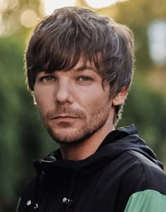 a close up of a person wearing a hoodie and looking at the camera with a serious look on his face