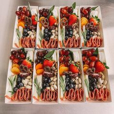 six square trays filled with assorted fruits and veggies on top of each other