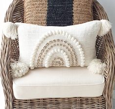 a wicker chair with two pillows on it